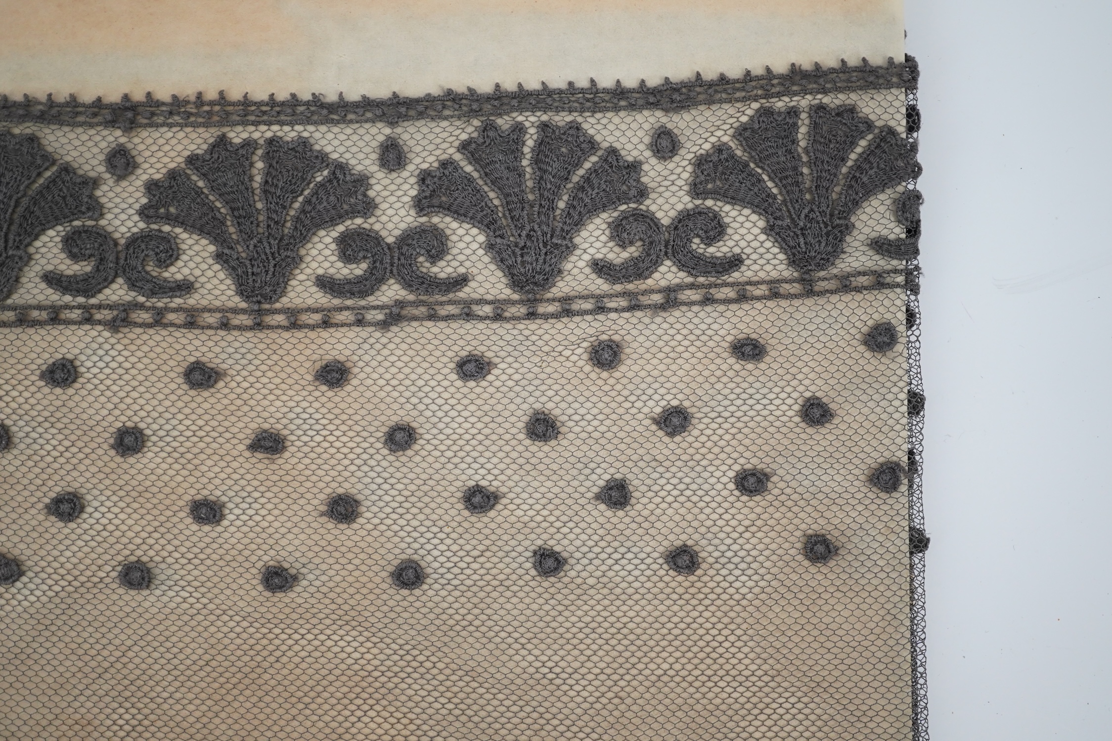 An unusual 19th century decorative length of charcoal grey machine furnishing lace, attributed to Christopher Dresser, together with a similar grey lace bonnet veil, both possibly Nottingham lace, furnishing lace 300cm j